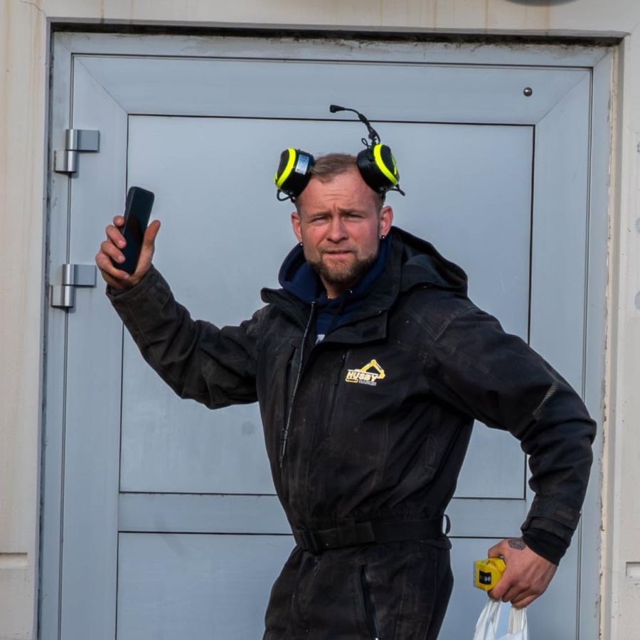 Terje Rasmussen fra Husby Maskin AS på jobb i arbeidstøy med firmalogo